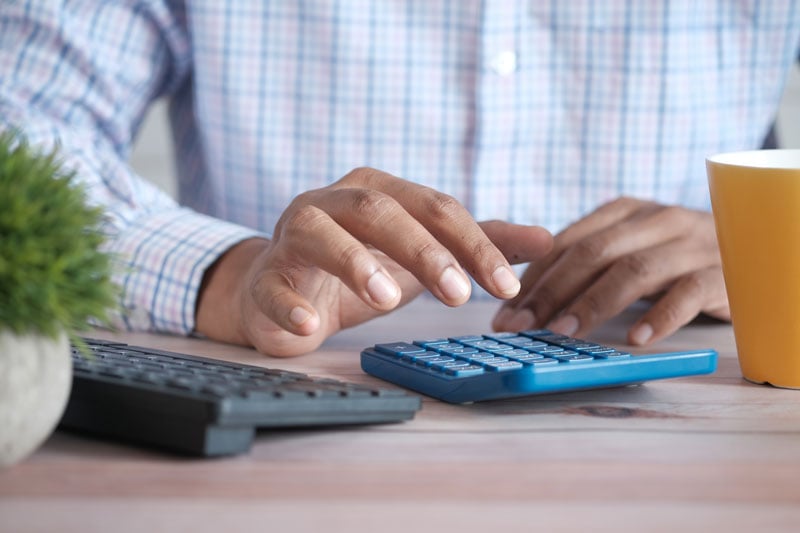 Blue calculator with someone holding it